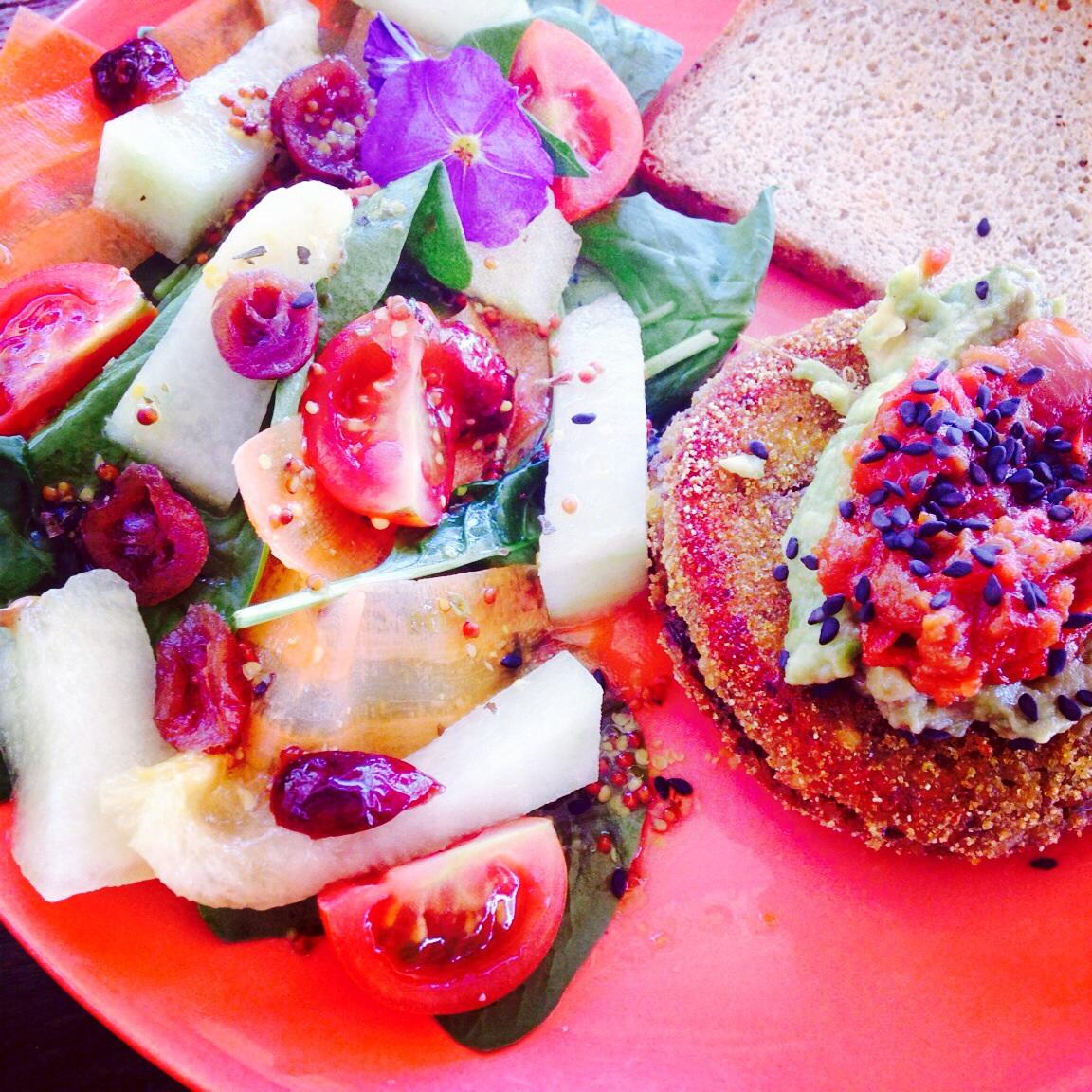 Sprouted lentil burger with guacamole and caramelised onion. Homemade gluten free bread. Melon and red berry salad.